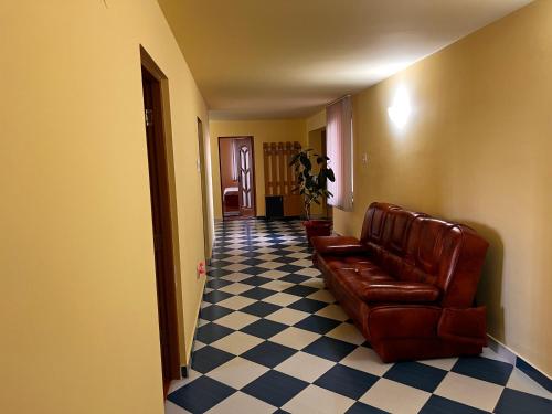 a hallway with a leather couch and a checkered floor at Vila Ovi Salin in Turda