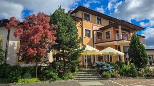 une grande maison avec des arbres devant elle dans l'établissement Hotel Ambasada, à Krobia