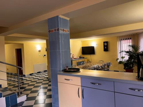 a kitchen with white cabinets and a tile floor at Vila Ovi Salin in Turda