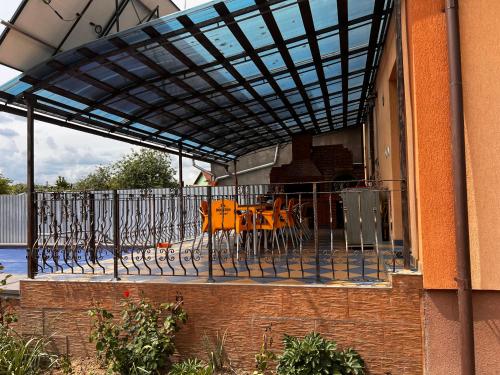 a patio with orange chairs and a fence at Vila Ovi Salin in Turda