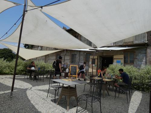 a group of people sitting at tables under a white umbrella at La Locanda della Mandria in Venaria Reale