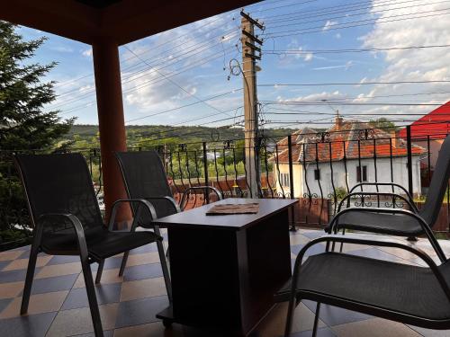 a balcony with chairs and a table and a view of a building at Vila Ovi Salin in Turda