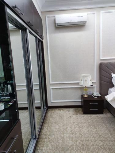 a hotel room with a bed and a mirror at Mansion Hotel in Stantsiya Kyzyl-Tukumachi