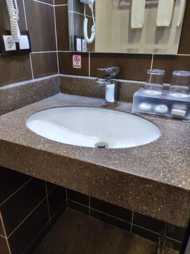 a bathroom counter with a white sink in a bathroom at Mansion Hotel in Stantsiya Kyzyl-Tukumachi