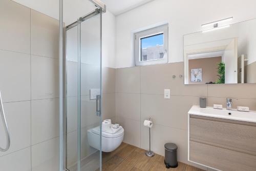 a bathroom with a shower and a toilet and a sink at Viganello Modern Apartments in Lugano