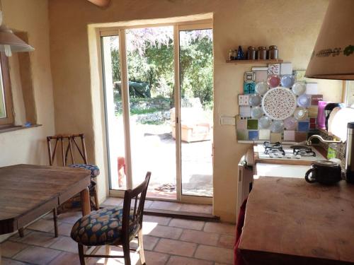 Sainte-Croix-de-CaderleにあるMas Belavista - 2 bedrooms, kitchen, terrace, viewのキッチン(テーブル、コンロ、ドア付)