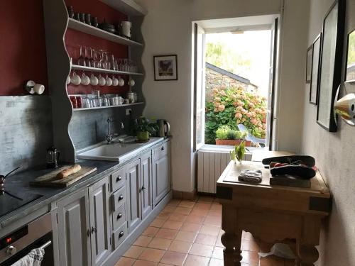 une cuisine avec un évier et une fenêtre dans l'établissement Ty Traez, holiday house for families in Cap Sizun, à Primelin
