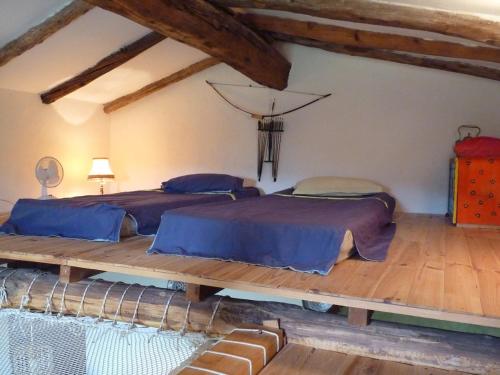 Sainte-Croix-de-CaderleにあるMas Belavista - 2 bedrooms, kitchen, terrace, viewのウッドフロアのベッドルーム1室(ベッド2台付)