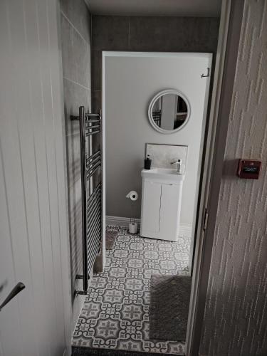 a hallway with a bathroom with a toilet and a mirror at The Wheatsheaf in Salisbury
