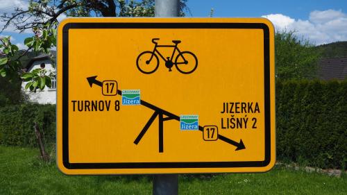 a yellow street sign with a bike on it at Holiday House Malá Skála in Malá Skála
