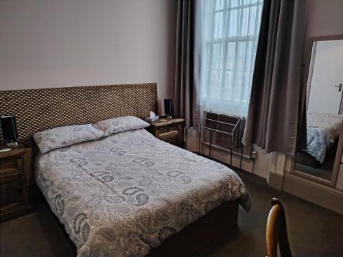a bedroom with a bed and a window at The Wheatsheaf in Salisbury