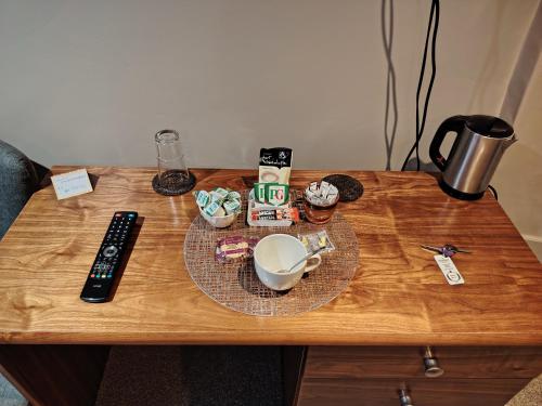 a table with a remote control and a plate of food at The Wheatsheaf in Salisbury