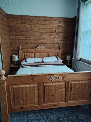 a large wooden bed in a bedroom with two lamps at The Wheatsheaf in Salisbury