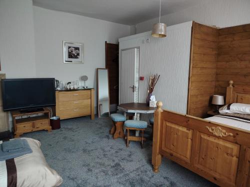 a bedroom with a bed and a desk and a television at The Wheatsheaf in Salisbury