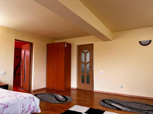 a bedroom with a bed and a door and rugs at Vila Ovi Salin in Turda