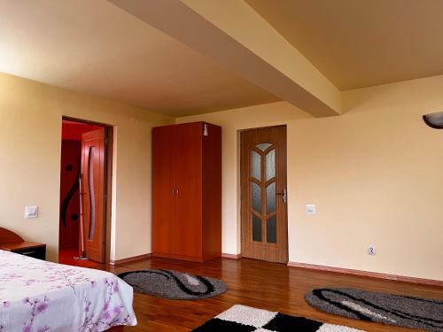 a bedroom with a bed and a door and two rugs at Vila Ovi Salin in Turda