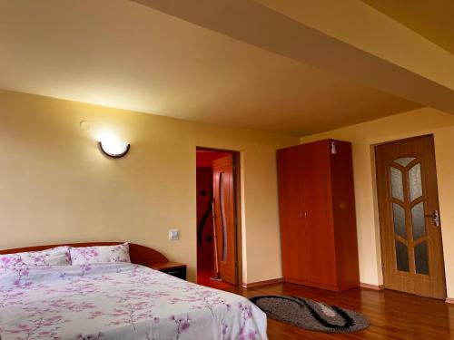 a bedroom with a bed and a wooden floor at Vila Ovi Salin in Turda