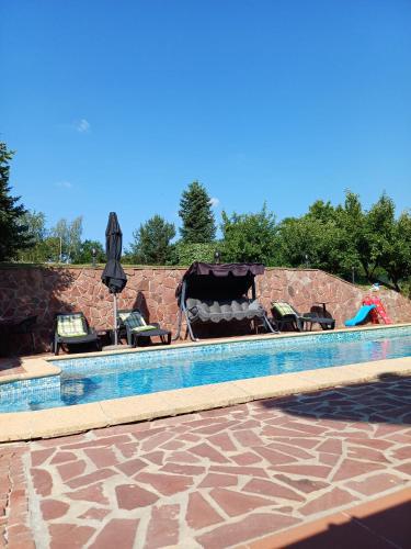a swimming pool with chairs and an umbrella at Villa Villekulla in Chukovezer