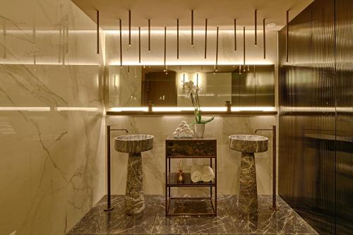 a room with a table with two stools and a mirror at Maritim Hotel Plaza Tirana in Tirana