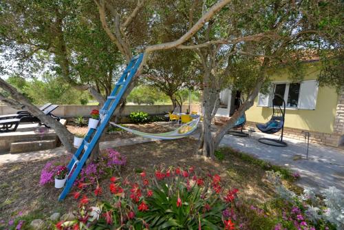 a blue ladder in a tree in a yard at House Ana in Banj