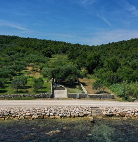 a stone wall next to a body of water at House Ana in Banj