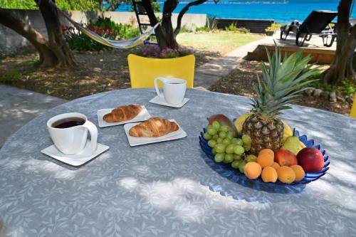 a table with a plate of fruit and a cup of coffee at House Ana in Banj
