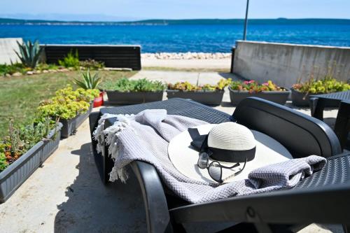 a table with a hat on top of it next to the beach at House Ana in Banj