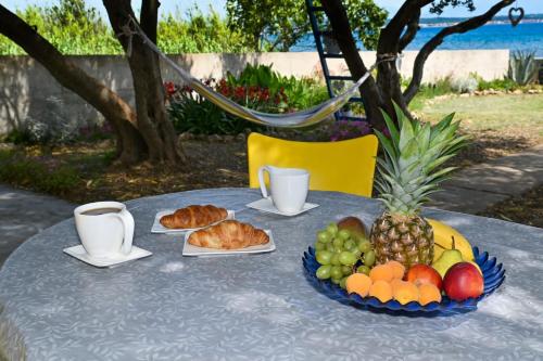 a table topped with a plate of fruit and croissants at House Ana in Banj