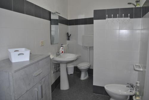 a white bathroom with a sink and a toilet at La Casa di Aldo e Maria in Marsala