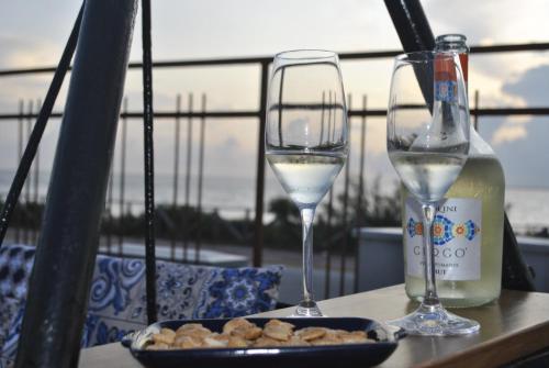 two glasses of white wine and a plate of food at La Casa di Aldo e Maria in Marsala
