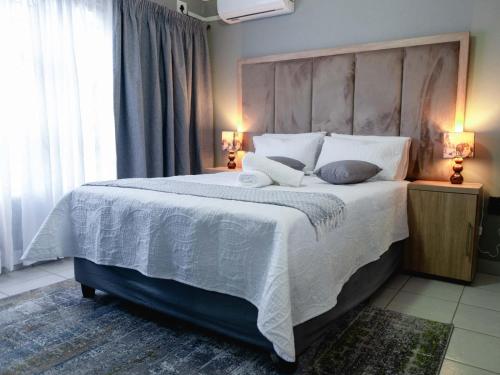 ファラボルワにあるViata Luxe Guesthouseの白いシーツと枕が付いた大きなベッドのある寝室
