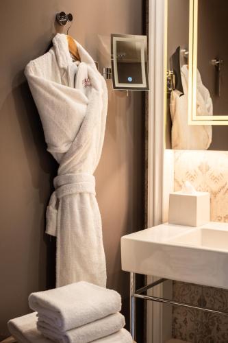 a pile of towels are hanging in a bathroom at Dolce by Wyndham Versailles - Domaine du Montcel in Jouy-en-Josas
