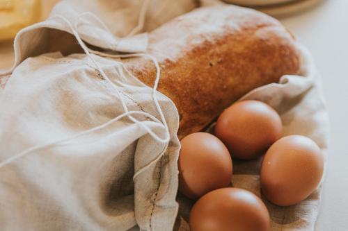 a bunch of eggs in a bag next to a loaf of bread at Drift Off Grid Luxury Eco Glamping in Tarakohe