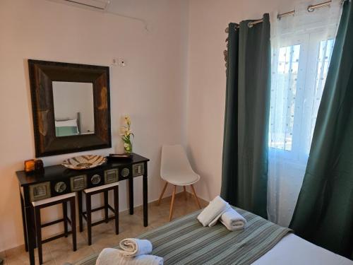 a bedroom with a table and a mirror and a bed at Nora Apartment in Almyrida in Chania Town