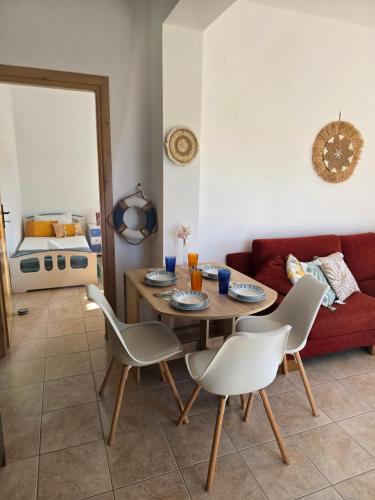 a living room with a table and a red couch at Nora Apartment in Almyrida in Chania Town