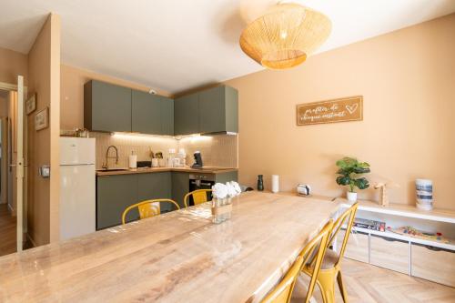 une cuisine et une salle à manger avec une grande table en bois dans l'établissement Gite 