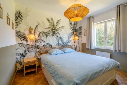 a bedroom with a bed with a palm mural on the wall at Gite "Douce Campagne" - Terrasse - 3 Chambres - Lits King & Queen size, lits superposés in Saint-Josse