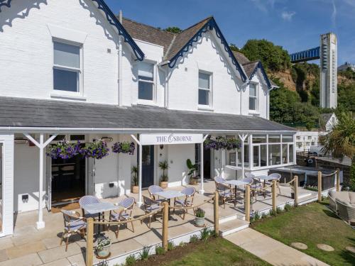 a patio with tables and chairs outside of a house at The Osborne in Shanklin
