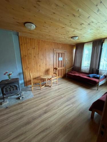 a living room with a couch and a bed and a table at Lauku viesu māja Bajāri in Rucava