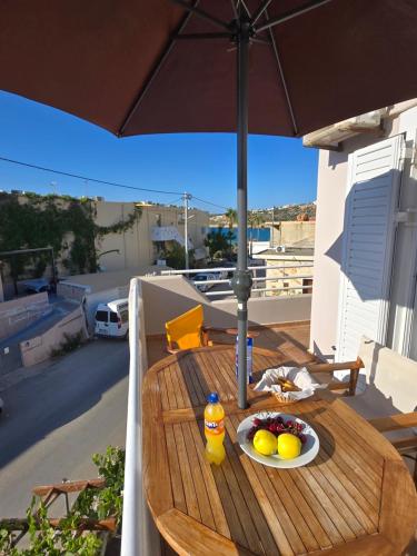 a table with a bowl of fruit and a bottle of orange juice at Nora Apartment in Almyrida in Chania Town