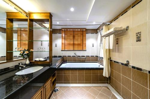 a bathroom with a tub and a sink at Sherwood Residence in Ho Chi Minh City