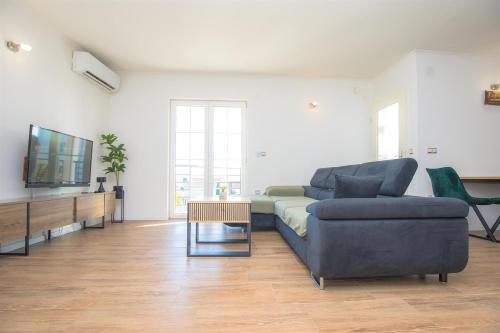 a living room with a couch and a tv at House Matilda in Primošten