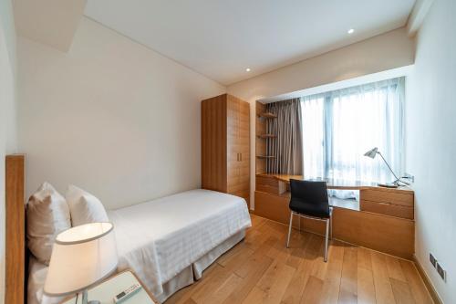 a hotel room with a bed and a desk at Sherwood Residence in Ho Chi Minh City
