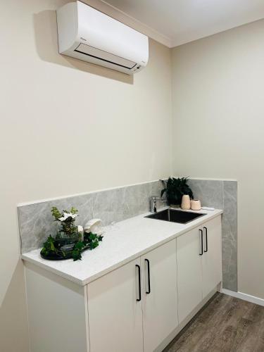 a kitchen with white cabinets and a sink at Modern One Bedroom Unit with Private Entrance Near Hunua Falls in Hunua