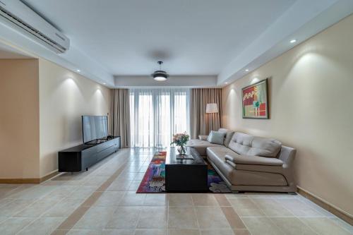 a living room with a couch and a television at Sherwood Residence in Ho Chi Minh City