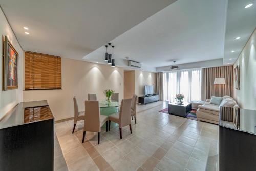a dining room and living room with a table and chairs at Sherwood Residence in Ho Chi Minh City