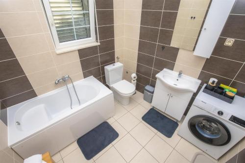 a bathroom with a tub and a toilet and a sink at House Matilda in Primošten