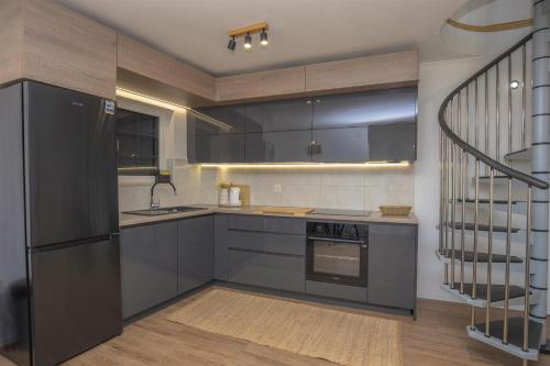 a kitchen with stainless steel appliances and a staircase at House Matilda in Primošten
