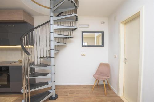 a spiral staircase in a kitchen with a chair at House Matilda in Primošten