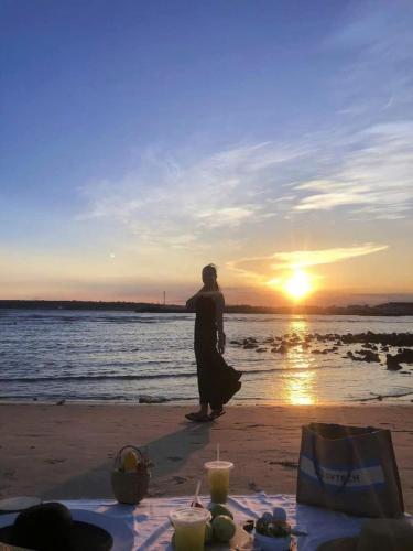 a person standing on the beach watching the sunset at Hoàng Nga 2 Homestay in Phan Thiet